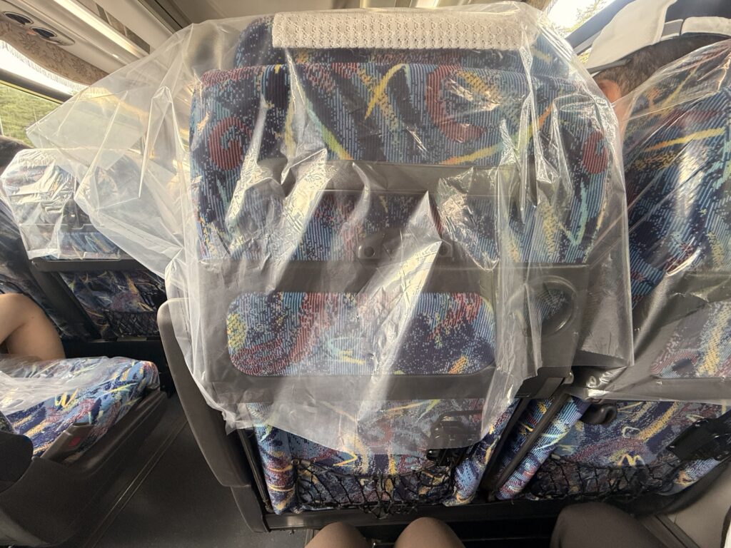 ビニールカバーがかけられたバスの座席